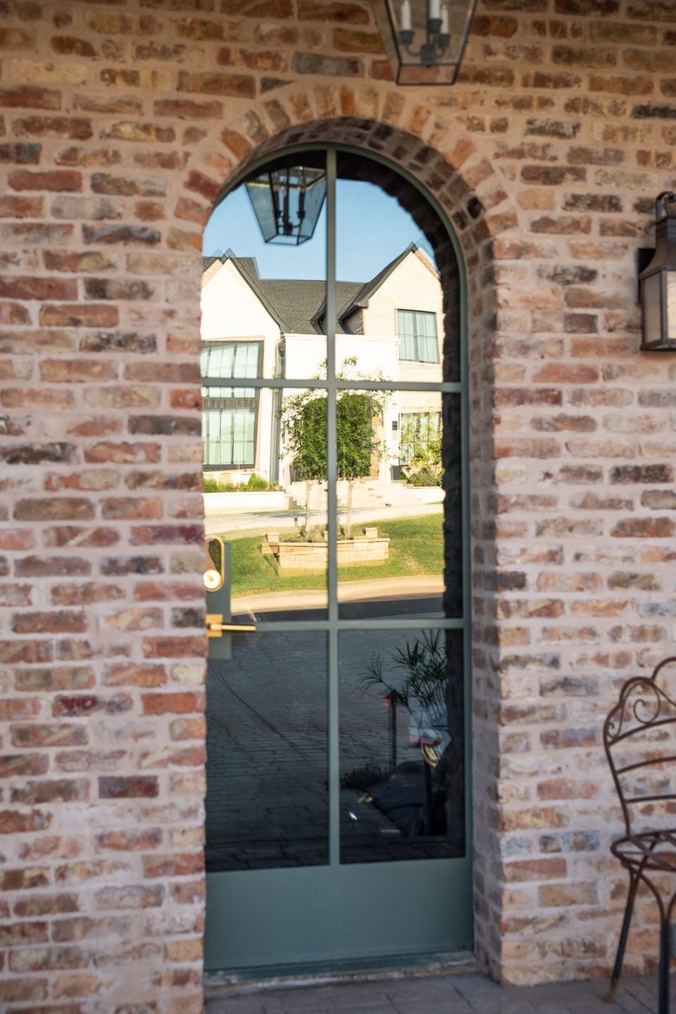 Real Green Window Cleaning detail of an arched glass entry door on a brick home